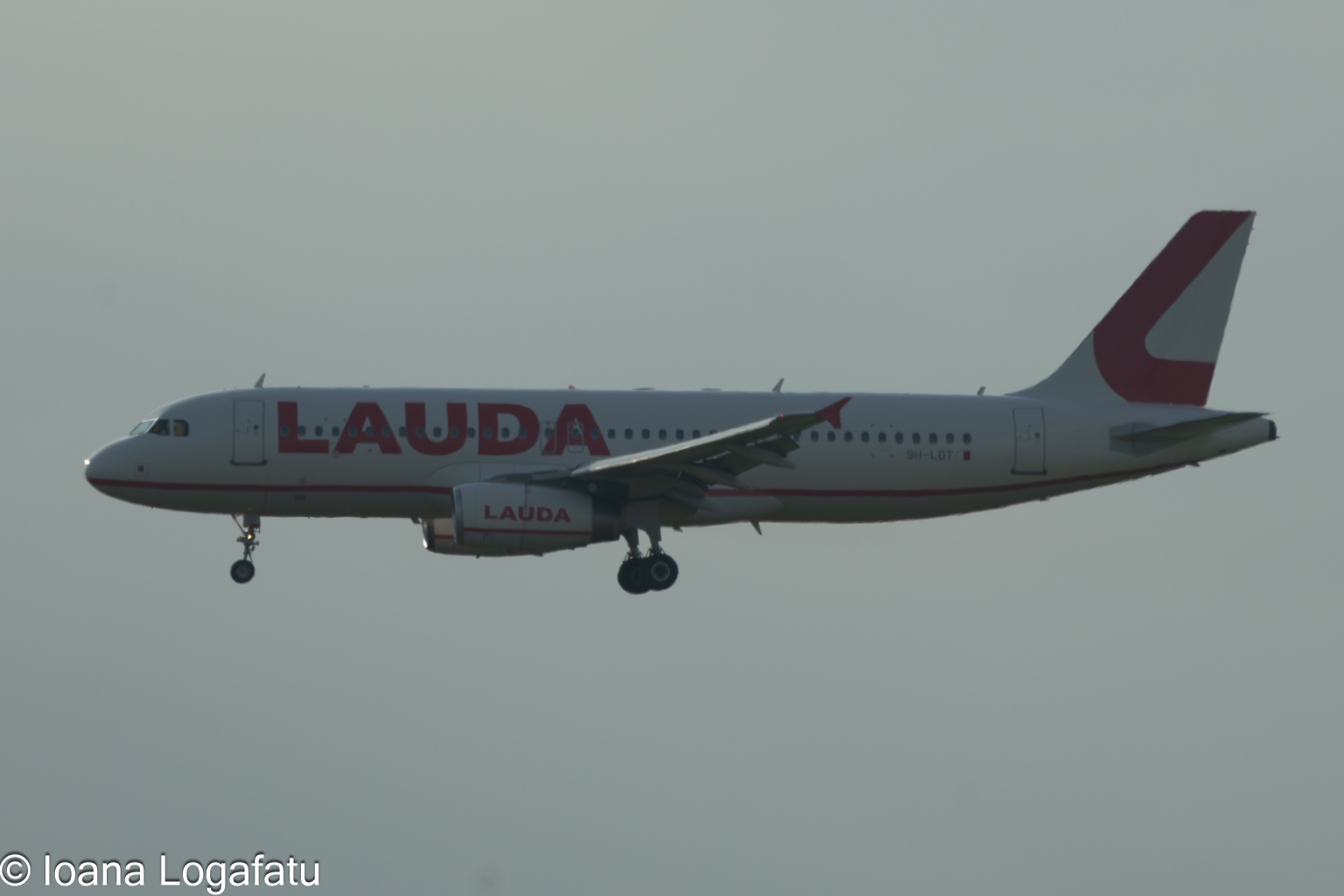 Airplane descends under cloudy skies at twilight